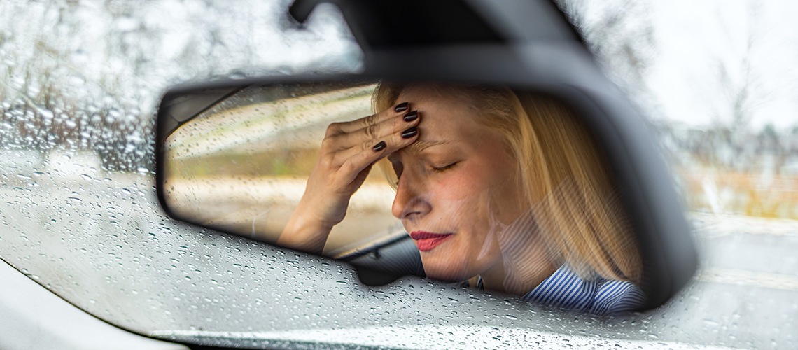 Vrouw hoofdpijn autospiegel