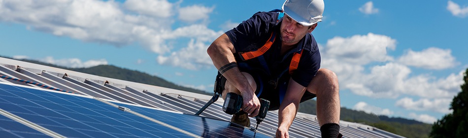 Man op een dak met zonnepanelen