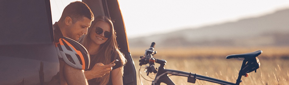 man en vrouw met racefiets  kijken naar smartphone
