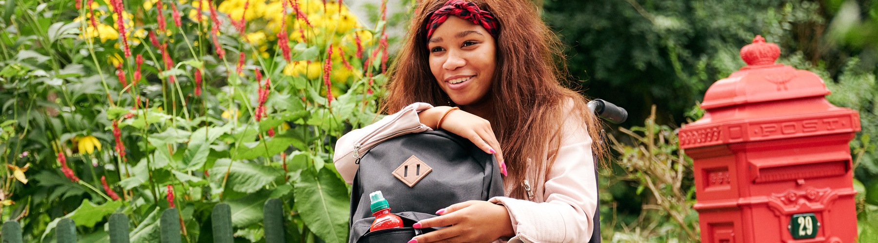 Meisje met tas in rolstoel