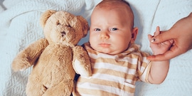 baby met knuffel in bed