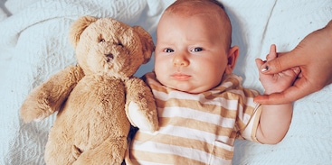 baby met knuffel in bed
