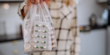 Vrouw houdt zakje met medicijnen vast