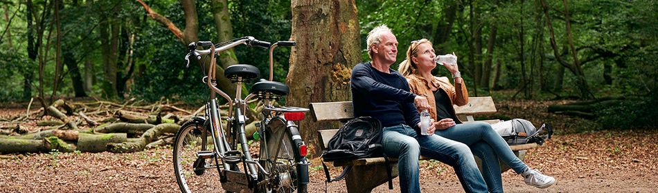 Mantelzorg - Mensen met fiets op bankje in het bos