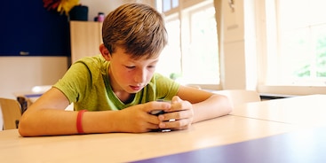 mantelzorg-jongen-schoolbank-telefoon
