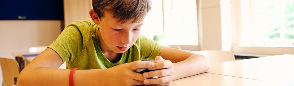 mantelzorg-jongen-schoolbank-telefoon