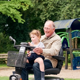 Opa met kleinkind in scootmobiel